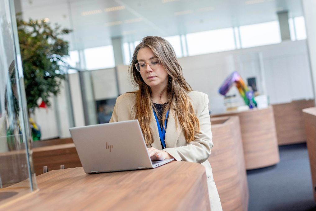 Portret van een collega bij BZ achter haar laptop. Bij BZ werk je aan belangrijke thema's zoals wereldwijde cyber security