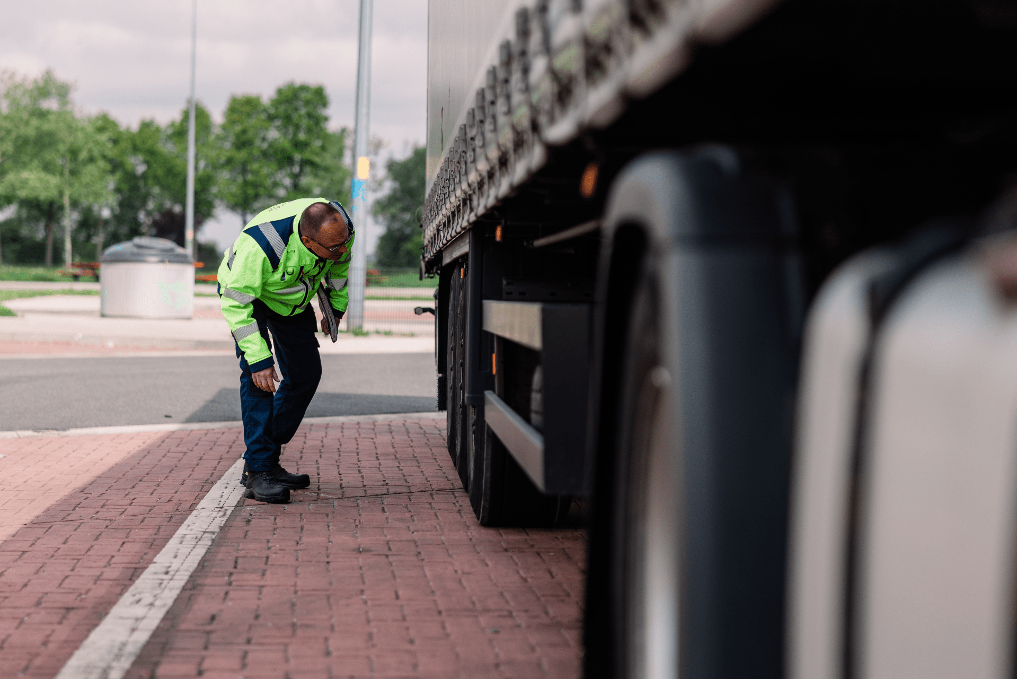 inspecteur vrachtwagenheffing bij de ILT Ron kijkt onder een vrachtwagen