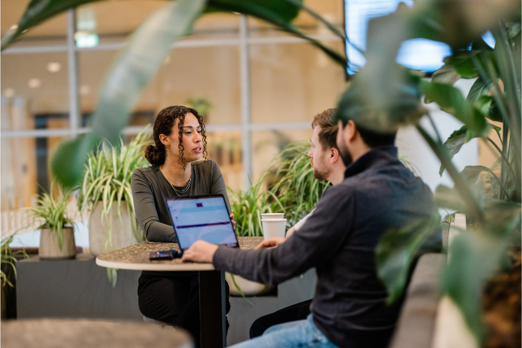 Collega's van het team criminele inlichtingen overleggen bij een laptop. Ze werken bij de Inlichtingen- en Opsporingsdienst van de Inspectie Leefomgeving en Transport