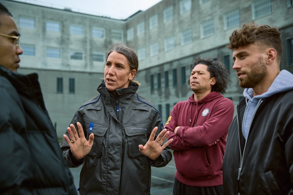 PIW-er aan het werk, ze is in gesprek met drie personen