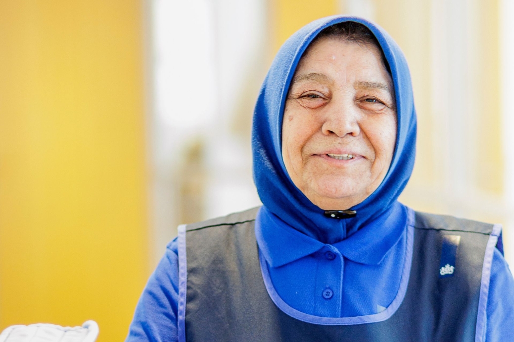 Portret van Alper. Zij werkt als schoonmaakmedewerker bij de Rijksschoonmaakorganisatie