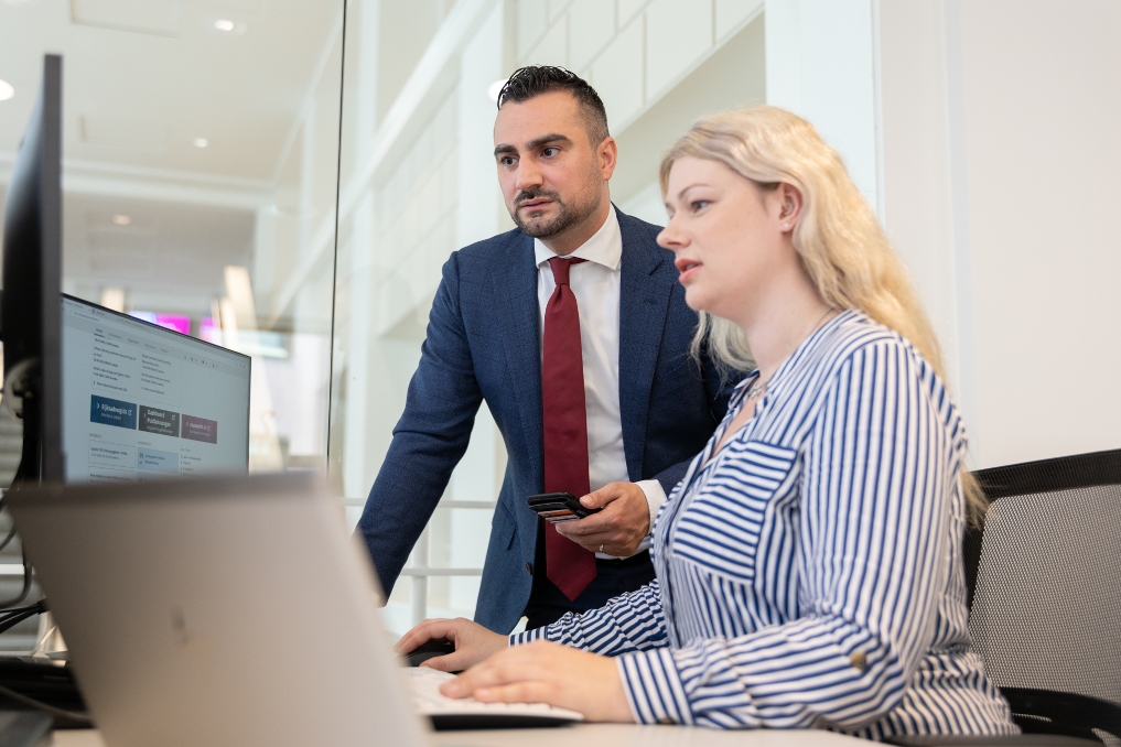 2 collega's van SZW werken samen aan een bureau