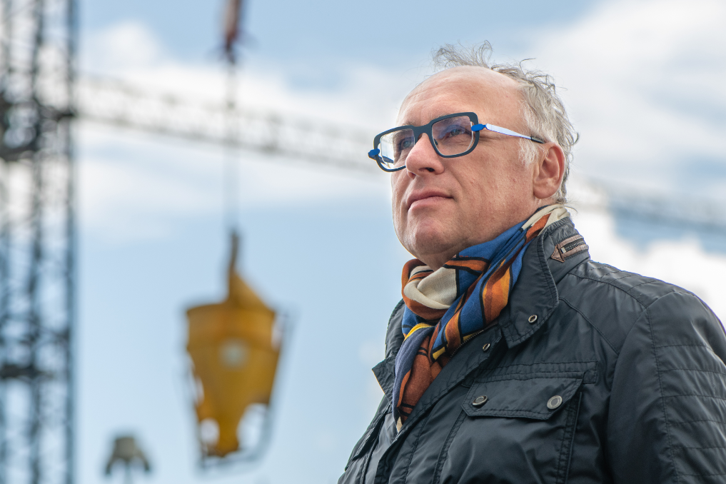 Henri Géron bij een hoogwerker op de bouwplaats