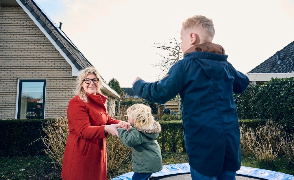 Marjolein met haar kinderen in de tuin bij de trampoline