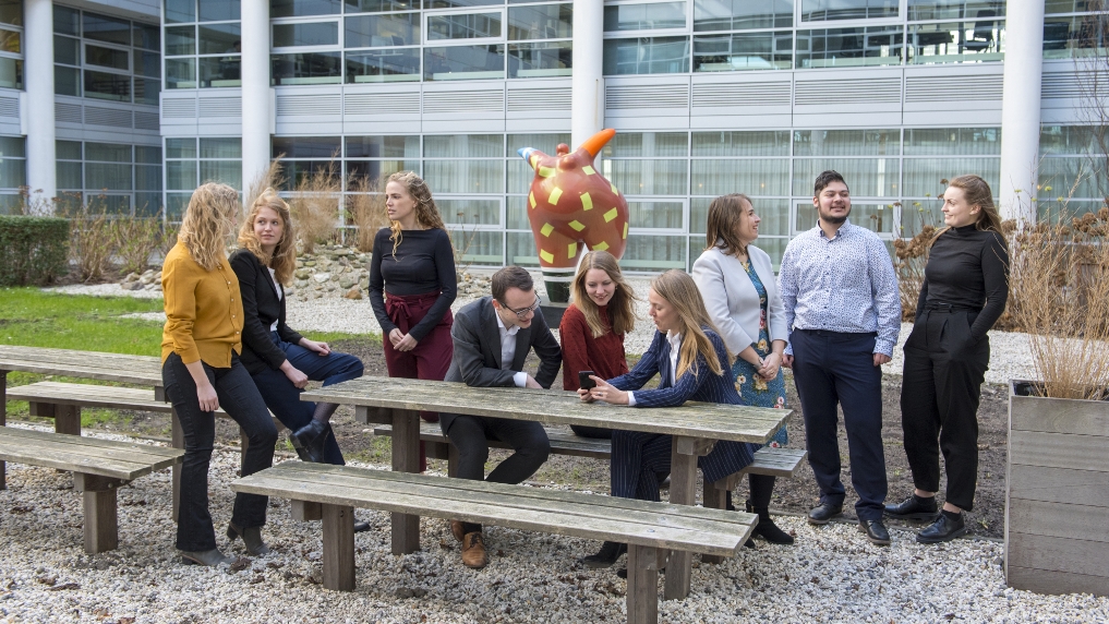 Foto van 9 trainees buiten bij een bank