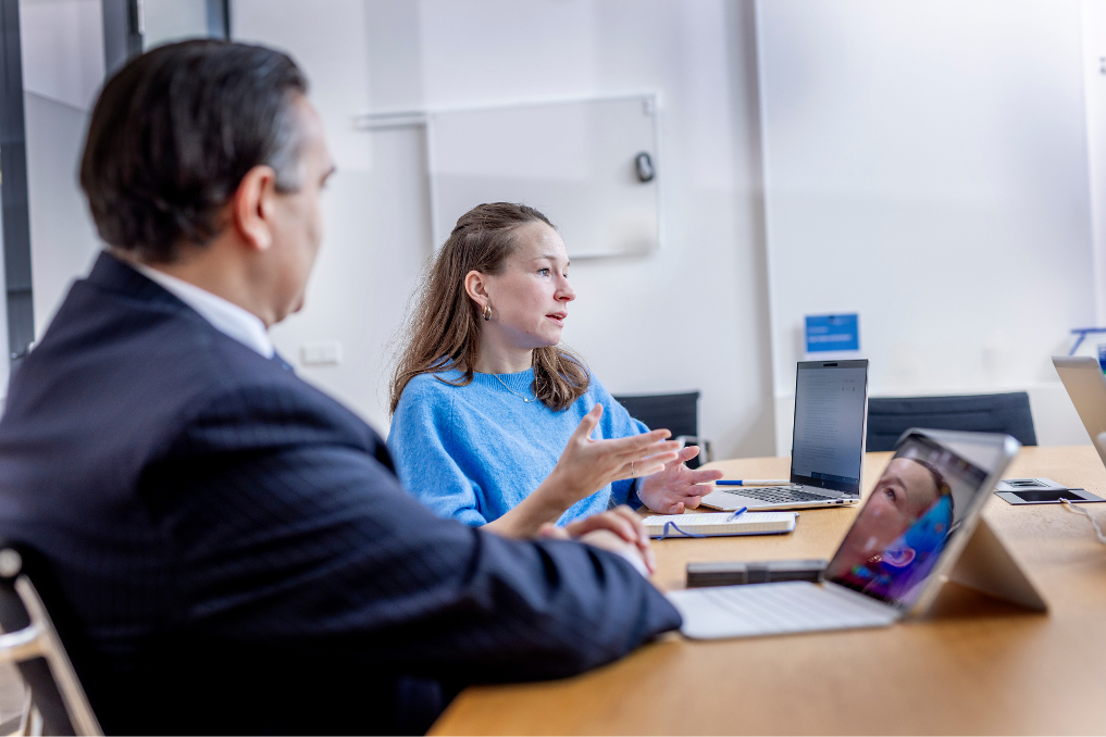 Juridisch adviseur bij de Rijksoverheid in gesprek met een collega
