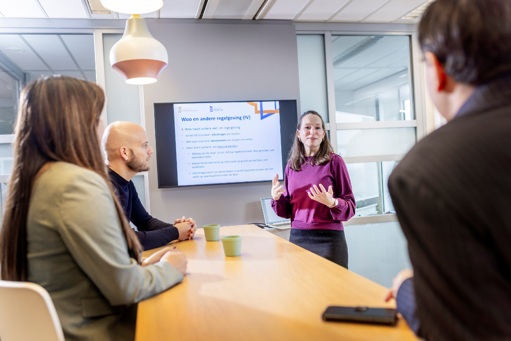 Roos geeft een presentatie aan collega's. Ze is jurist bij de Rijksoverheid